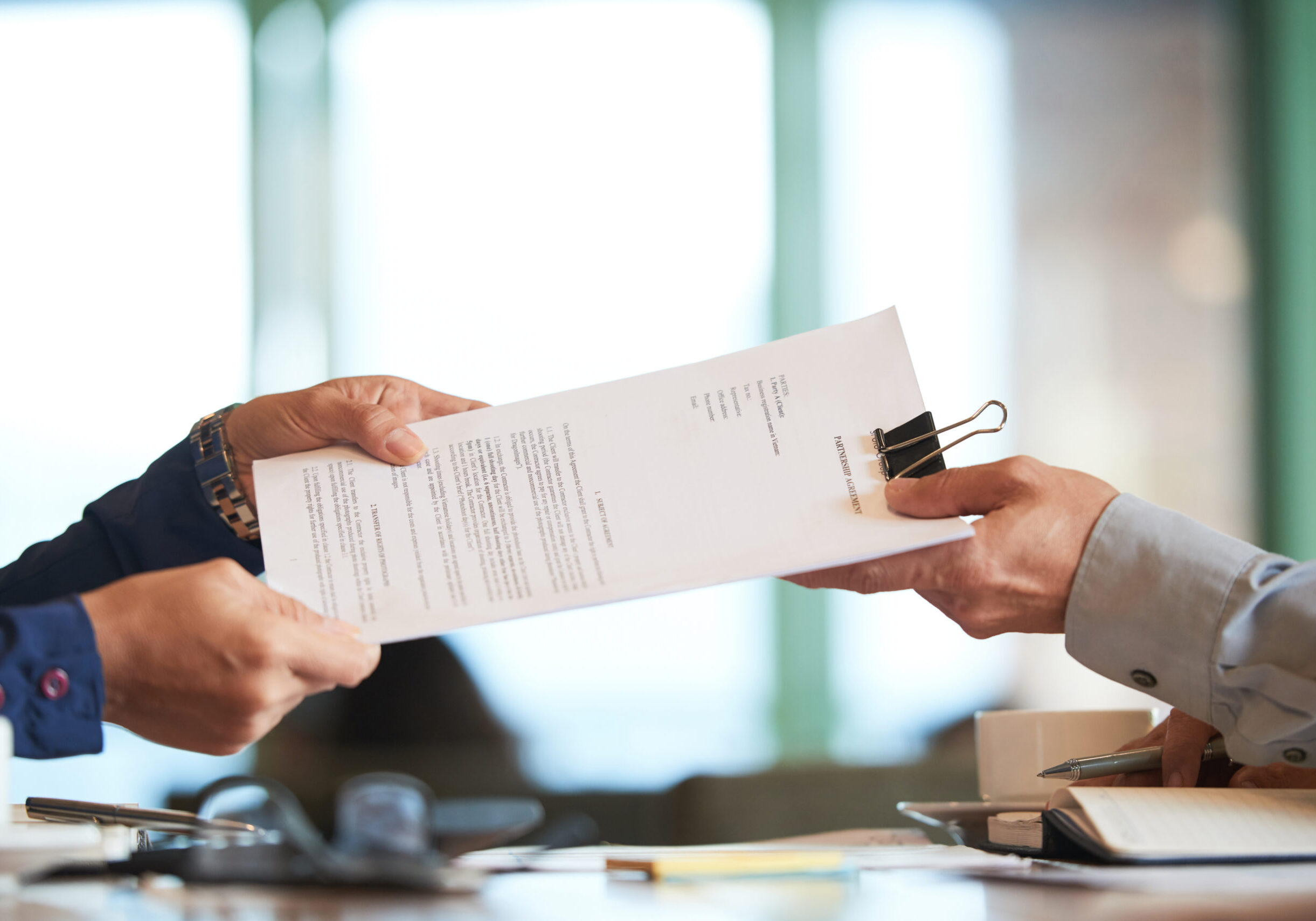 Business person giving partnership agreement to coworker